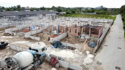 Aerial view of residential construction site with multiple houses in progress, showcasing modern development.