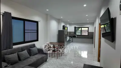 Spacious modern living room with open kitchen layout and sleek furnishings