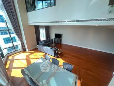 Spacious modern living room with high ceilings and large windows offering abundant natural light.