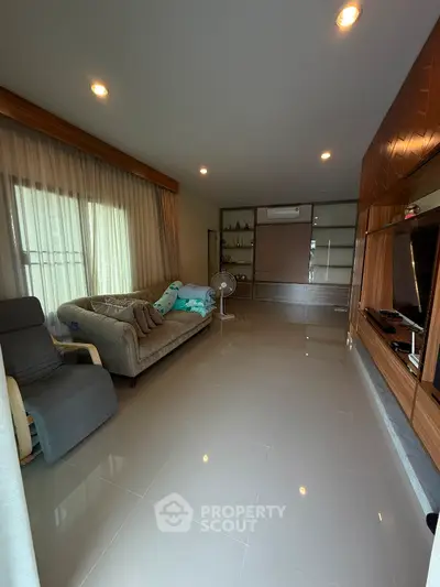 Spacious modern living room with sleek tile flooring and cozy seating area.