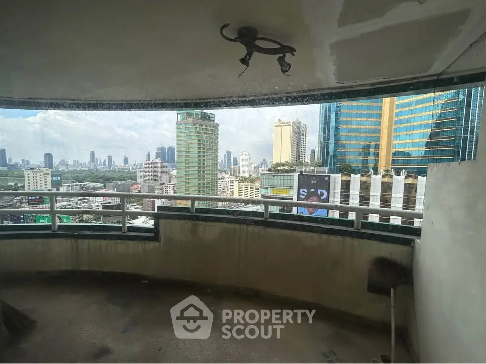 Spacious balcony with panoramic city views in high-rise building.