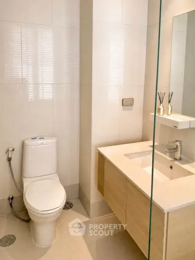 Modern bathroom with sleek fixtures and elegant design, featuring a toilet and stylish vanity.