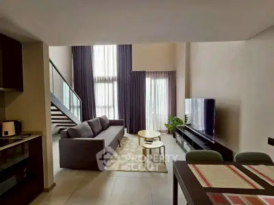 Spacious modern living room with high ceilings and stylish decor in a luxury apartment.