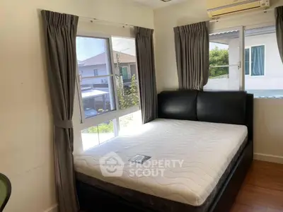 Cozy bedroom with large windows and modern furnishings, perfect for natural light lovers.