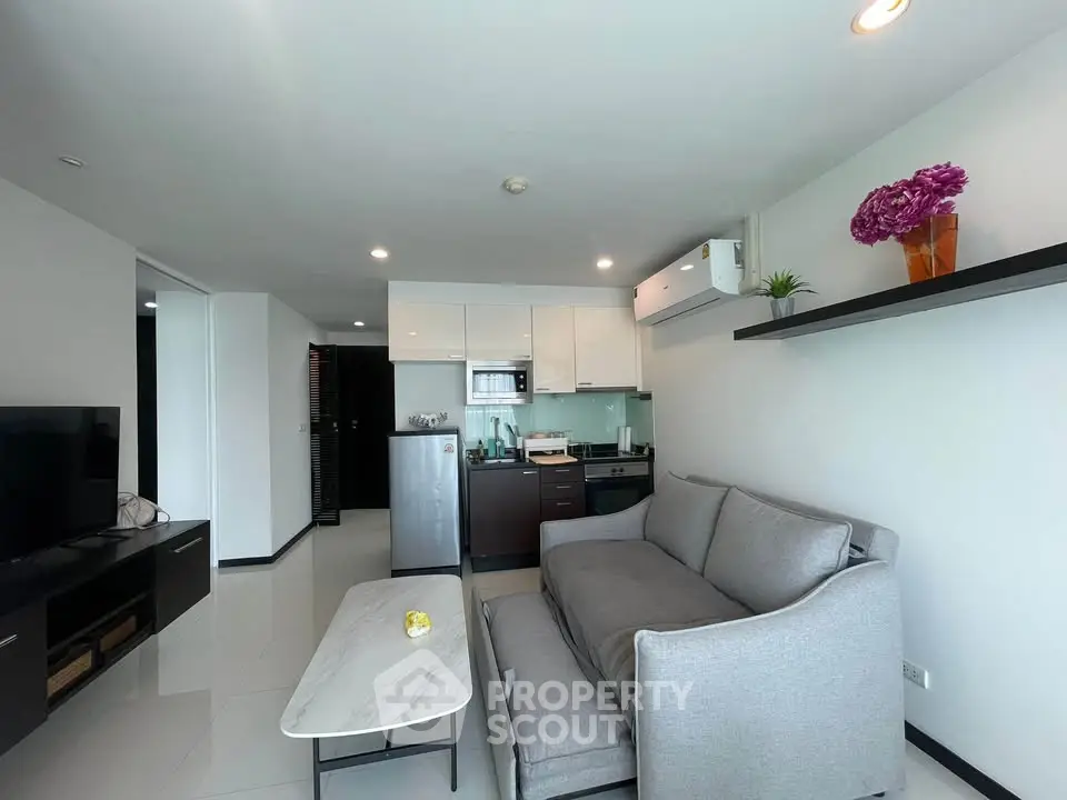 Modern living room with sleek furniture and open kitchen layout in a stylish apartment.