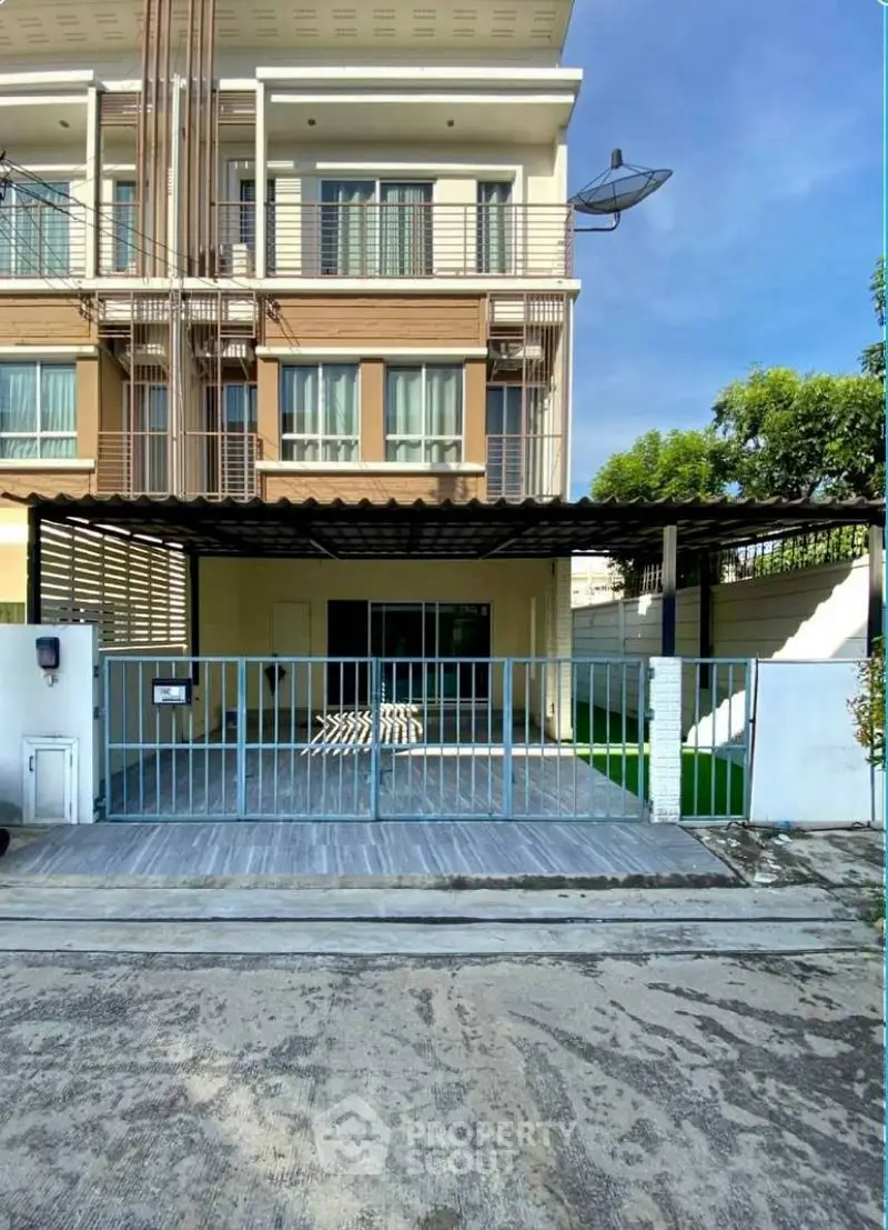 Modern townhouse exterior with gated parking and balcony, ideal for urban living.