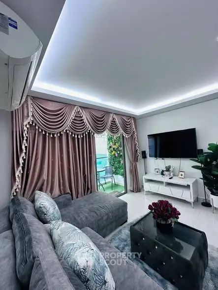 Luxurious living room with elegant drapes, plush sofa, and modern decor