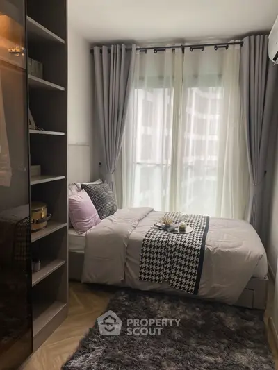 Cozy modern bedroom with stylish decor and large window for natural light.