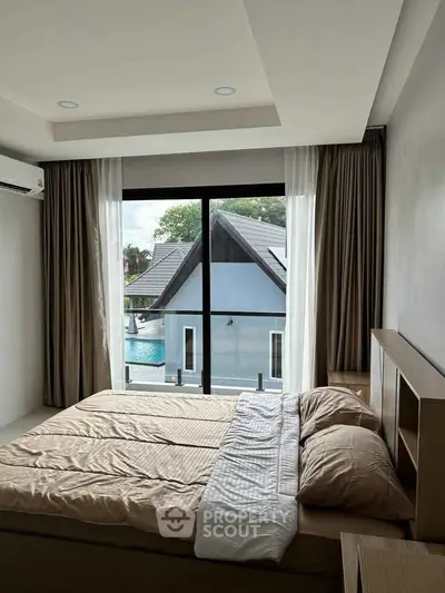 Modern bedroom with large window offering a stunning view of a pool and neighboring house.