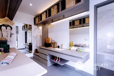 Modern kitchen with sleek gray cabinetry and white marble accents, featuring high-end appliances and stylish open shelving.