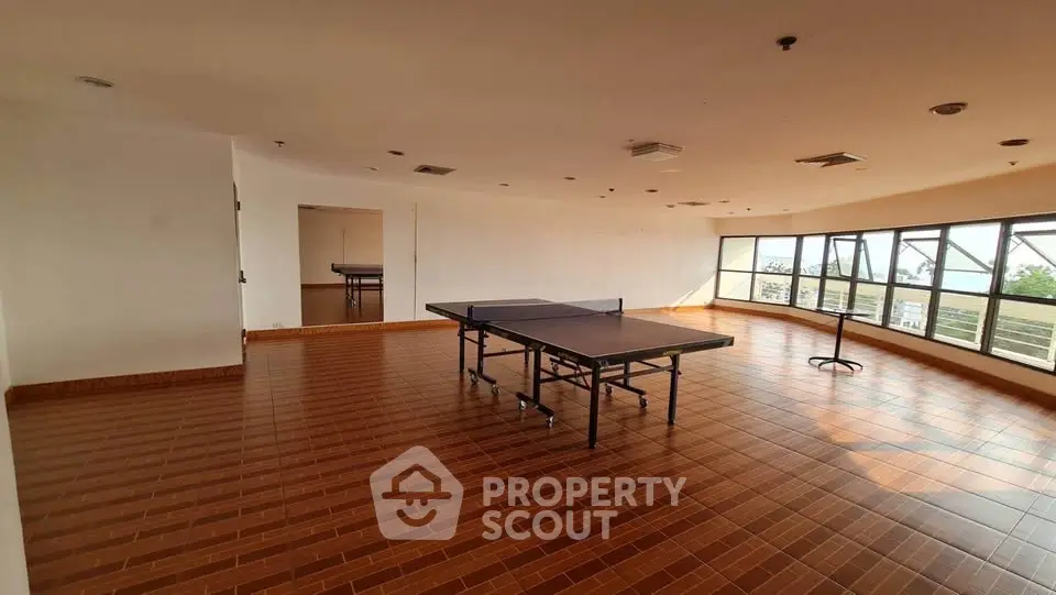 Spacious recreational room with ping pong table and large windows offering scenic views.