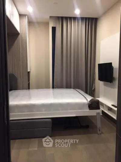 Modern compact bedroom with sleek design and wall-mounted TV