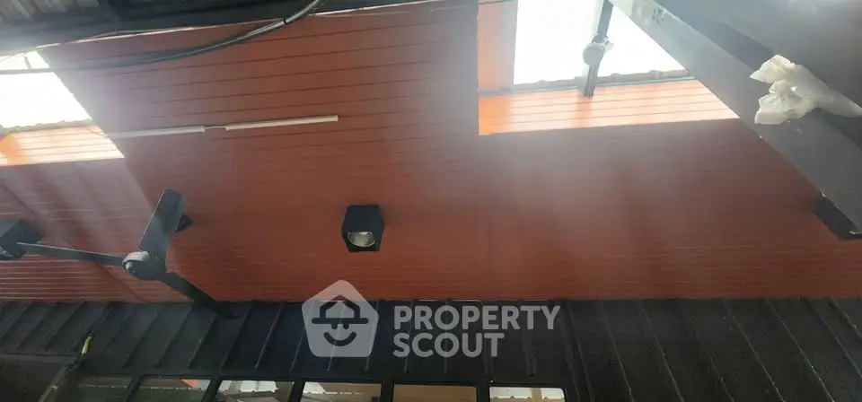 Modern ceiling design with skylights and industrial lighting in a contemporary building.