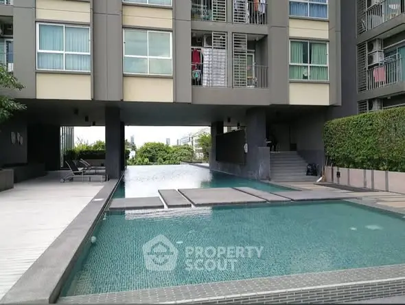 Modern apartment building with stylish pool and lush greenery