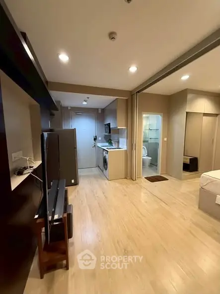 Modern open-plan studio apartment with sleek kitchen and cozy living area.