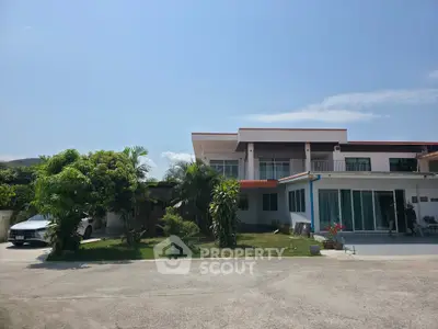 Spacious modern house with lush greenery and ample parking space, perfect for family living.