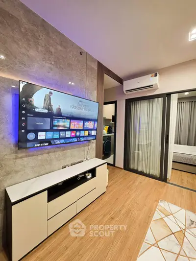 Modern living room with wall-mounted TV and sliding glass doors leading to a cozy bedroom.
