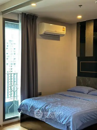 Modern bedroom with balcony access in a high-rise apartment, featuring sleek design and natural light.