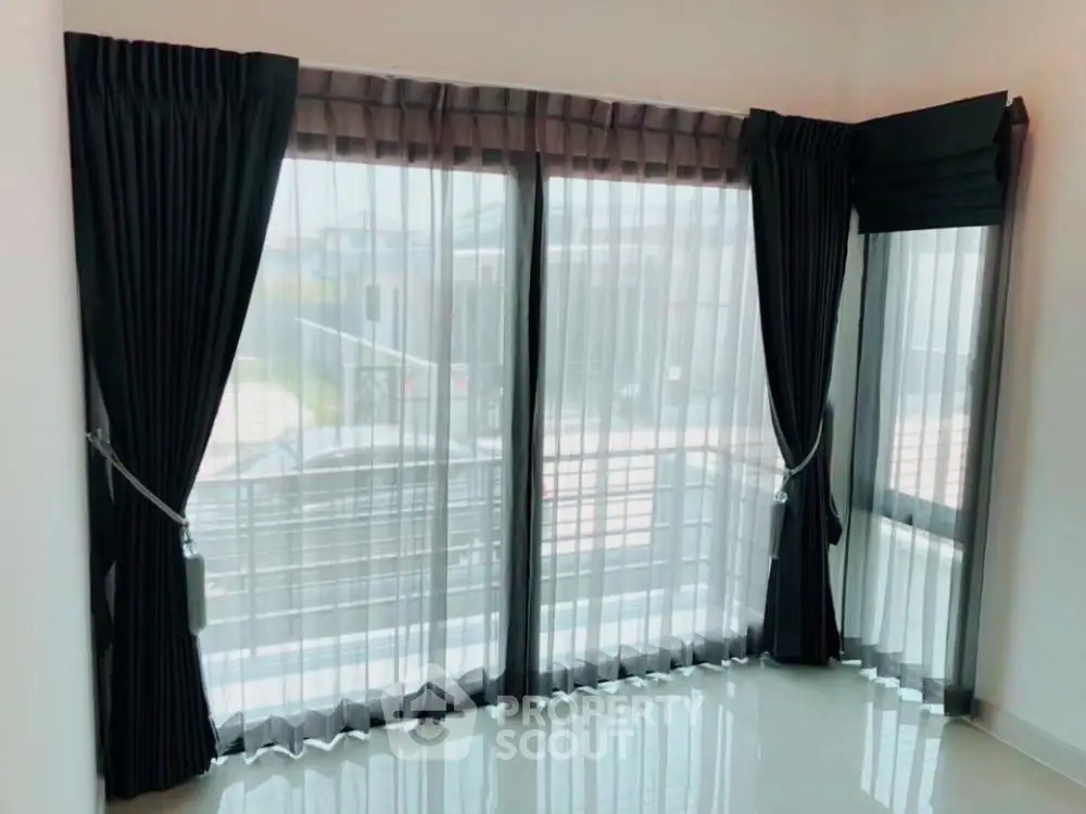 Bright corner unit with large windows and elegant curtains in modern apartment