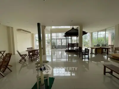Spacious indoor area with large windows and wooden seating, perfect for gatherings.