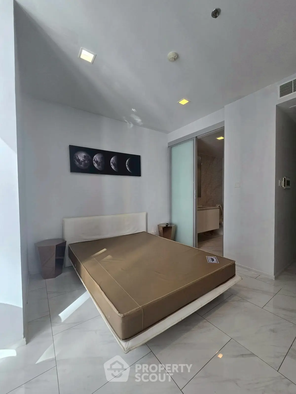 Modern bedroom with sleek design and moon phase artwork, featuring a minimalist aesthetic and natural light.