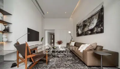Modern living room with stylish decor and contemporary furniture, featuring a large artwork and sleek design.