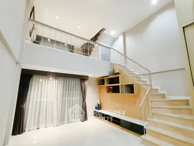 Spacious modern living room with high ceiling and stylish staircase