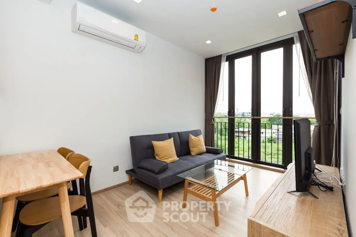 Modern living room with balcony view, featuring sleek furniture and natural light.