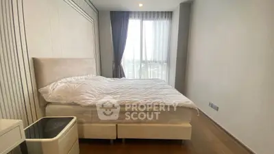 Modern bedroom with large window and stylish decor in a high-rise apartment.