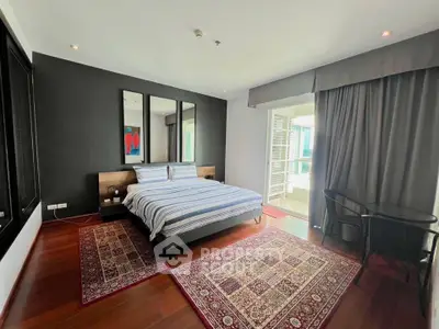 Spacious modern bedroom with elegant decor and large windows offering natural light.