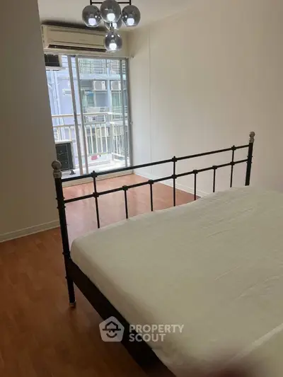 Spacious bedroom with modern decor and balcony access in urban apartment