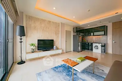Modern living room with open kitchen, featuring sleek appliances and stylish decor.