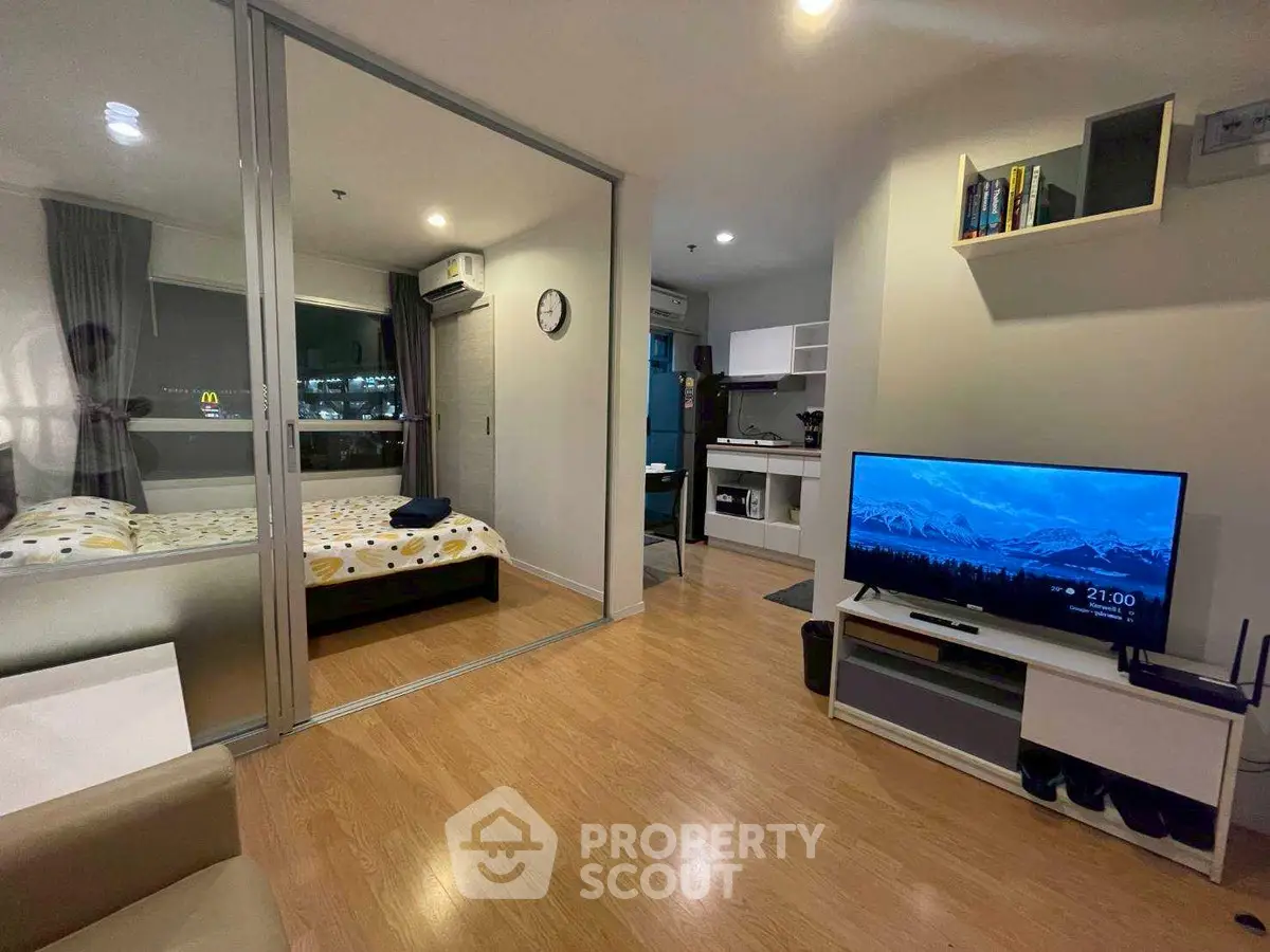 Modern studio apartment with open layout, featuring a cozy living area and compact kitchen.