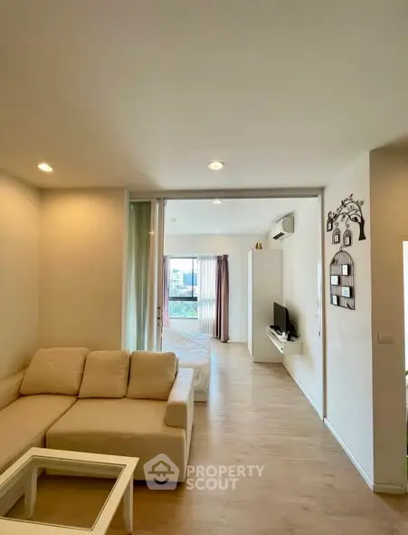 Spacious modern living room with cozy beige sofa and open layout design.