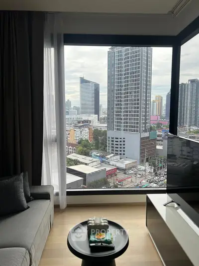 Modern living room with stunning city view through large windows in high-rise apartment.