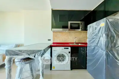 Modern kitchen with washing machine and sleek black cabinets
