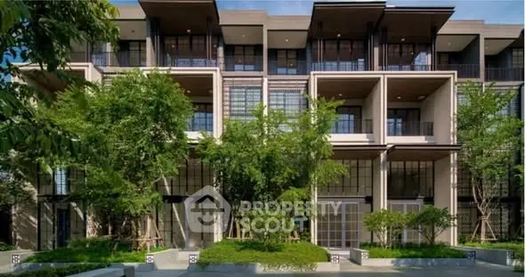 Modern multi-story building with lush greenery and large windows