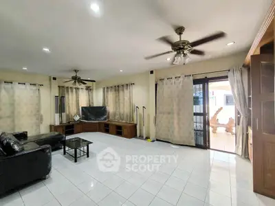Spacious living room with modern ceiling fans and large windows for natural light.