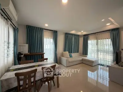 Spacious living room with modern decor and large windows in a stylish apartment.
