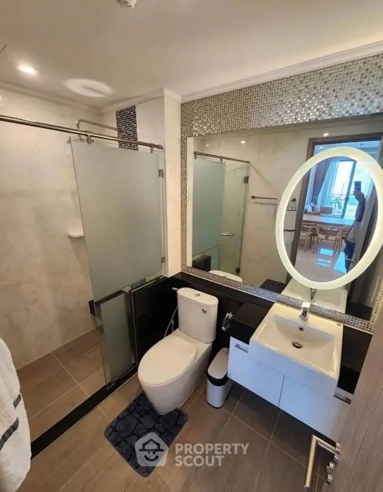 Modern bathroom with sleek fixtures and glass shower in contemporary apartment.