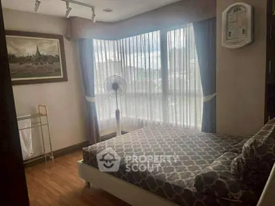 Cozy bedroom with large windows and stylish decor in modern apartment