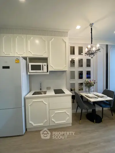 Stylish modern kitchen with elegant dining area and chandelier lighting