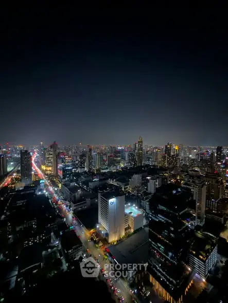 Stunning cityscape view from a high-rise building at night, showcasing vibrant city lights and skyline.