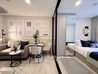 Modern open-plan living room with stylish decor and cozy bedroom area