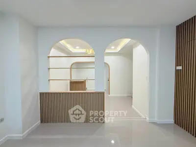 Modern interior with elegant arches and wooden accents, perfect for stylish living.