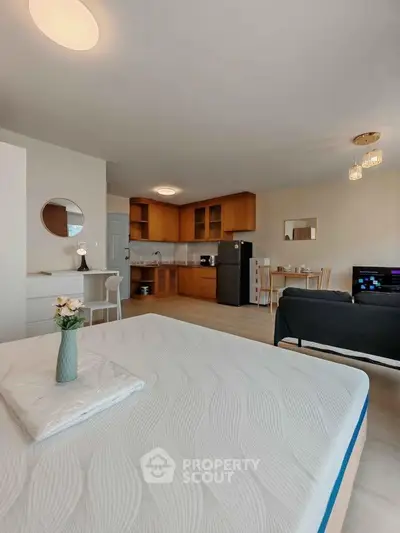 Spacious open-plan studio with modern kitchen and cozy living area, perfect for urban living.