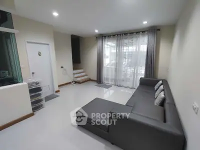 Modern living room with sleek gray sectional sofa and large window for natural light.