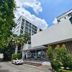 Modern apartment building with lush greenery and clear blue sky