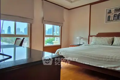 Spacious bedroom with city view and elegant furnishings in modern apartment