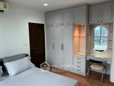 Spacious bedroom with built-in wardrobe and city view, perfect for urban living.